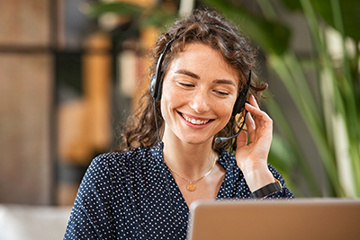 Woman talking on phone in front of a computer